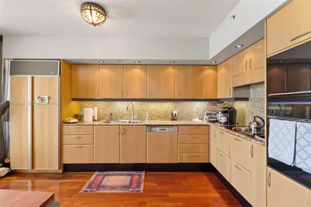 a kitchen with granite countertop a sink window and cabinets