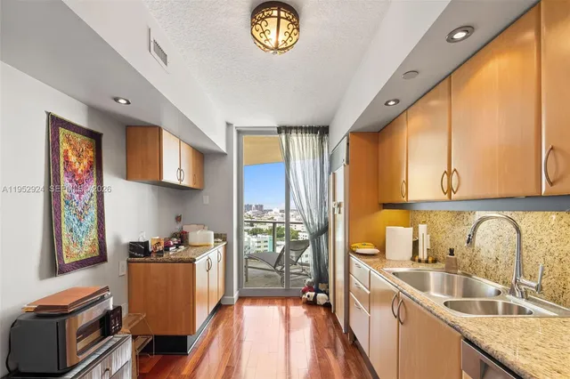 a kitchen with stainless steel appliances granite countertop a sink stove and cabinets