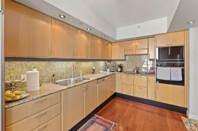 a kitchen with a sink a stove and cabinets