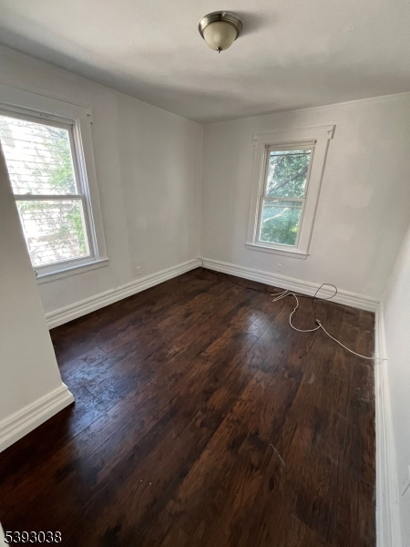 279 Renner Avenue, Unit 2 Newark, NJ 07112 - Photo 7 of 12 an empty room with wooden floor and windows