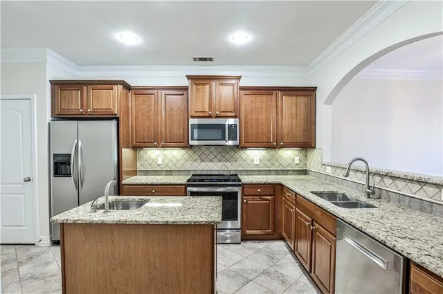 a kitchen with kitchen island granite countertop a sink stove and refrigerator
