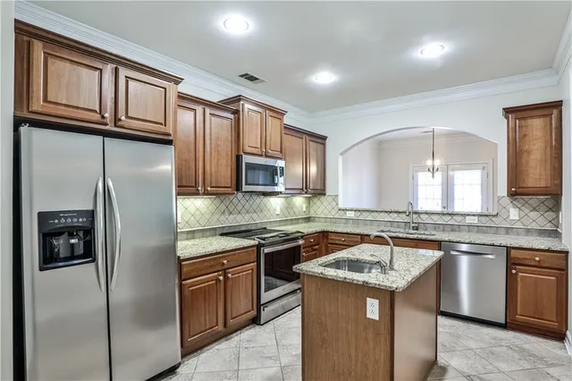 a kitchen with stainless steel appliances granite countertop a sink stove and refrigerator