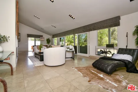 a patio with a table and chairs and potted plants