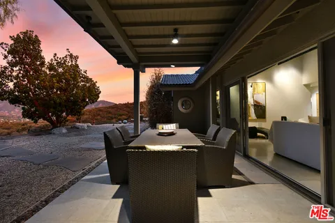 a dining room with furniture and a floor to ceiling window