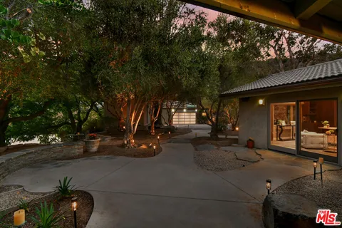 a view of a house with backyard and sitting area