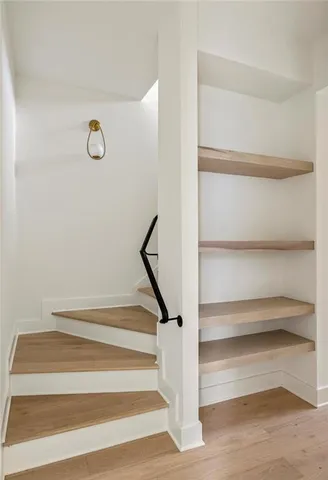 a view of a hallway with wooden floor and staircase