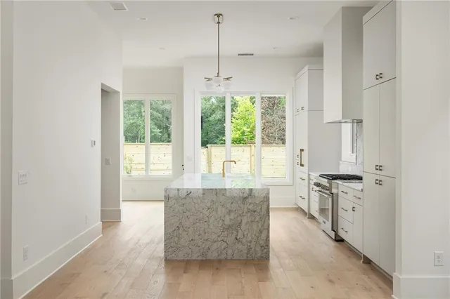 a large living room with stainless steel appliances granite countertop furniture a large window a sink and a granite counter top