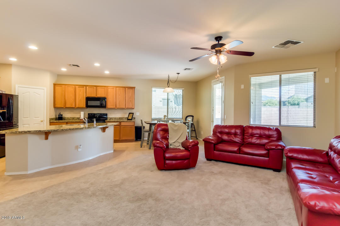 16528 West Sherman Street Goodyear, AZ 85338 - Photo 13 of 33 a living room with furniture kitchen view and a chandelier
