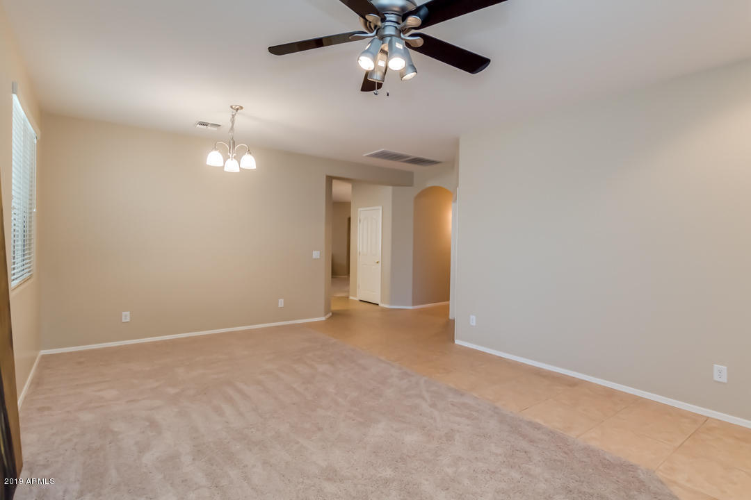 16528 West Sherman Street Goodyear, AZ 85338 - Photo 15 of 33 a view of an empty room with a chandelier fan