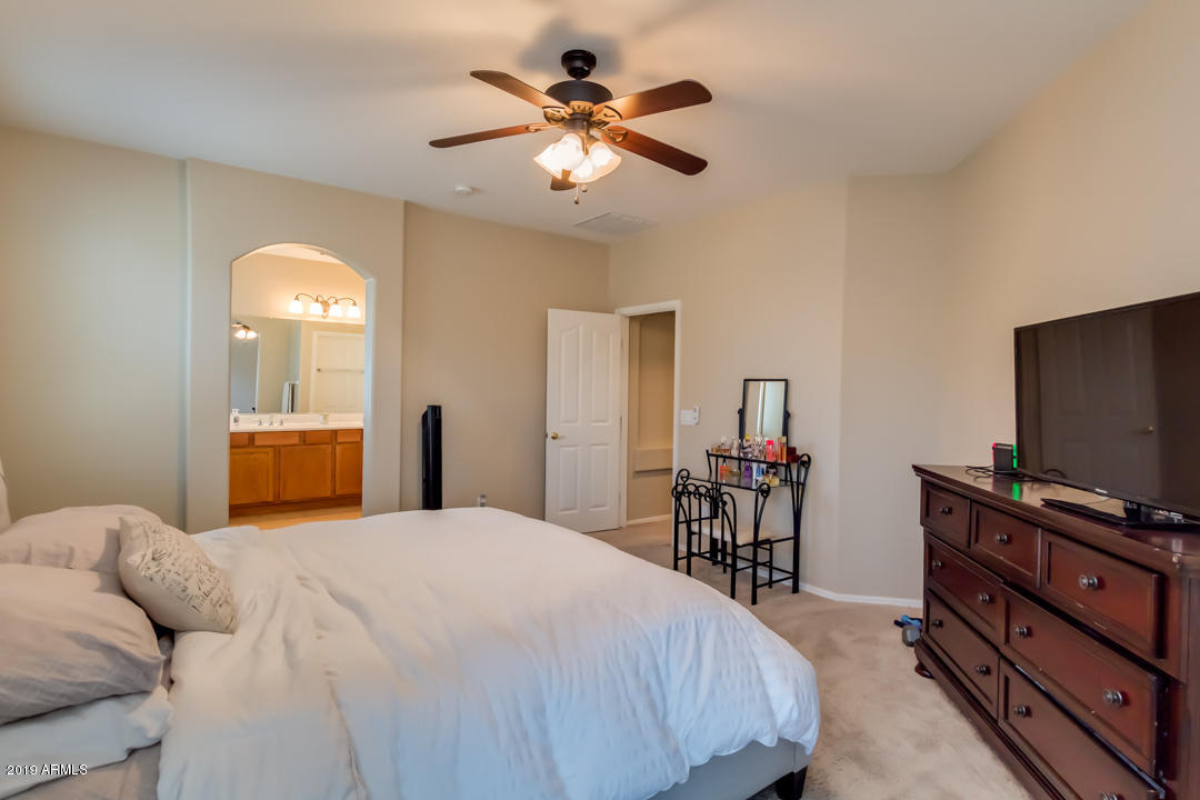 16528 West Sherman Street Goodyear, AZ 85338 - Photo 22 of 33 a bedroom with a bed and a flat screen tv with the dresser