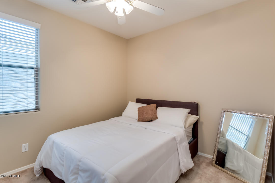 16528 West Sherman Street Goodyear, AZ 85338 - Photo 25 of 33 a bedroom with a bed and a mirror