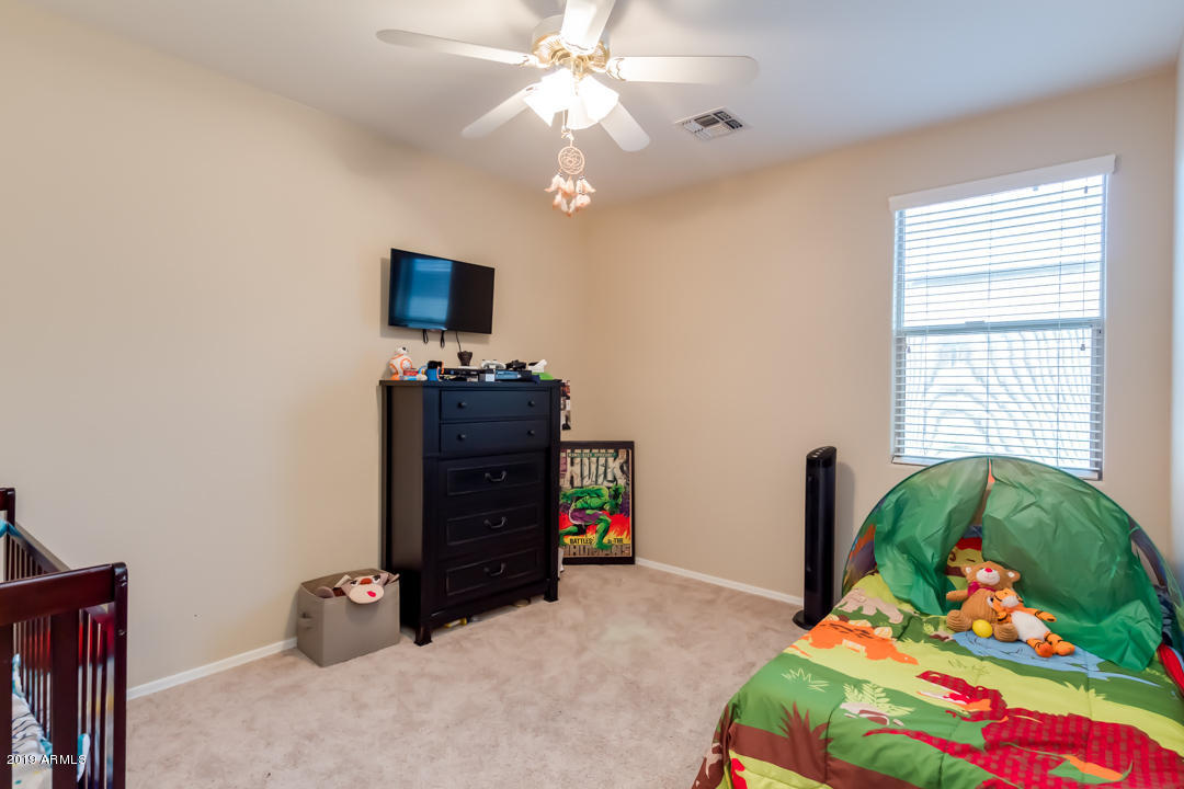 16528 West Sherman Street Goodyear, AZ 85338 - Photo 26 of 33 a bedroom with a bed and a baby bed