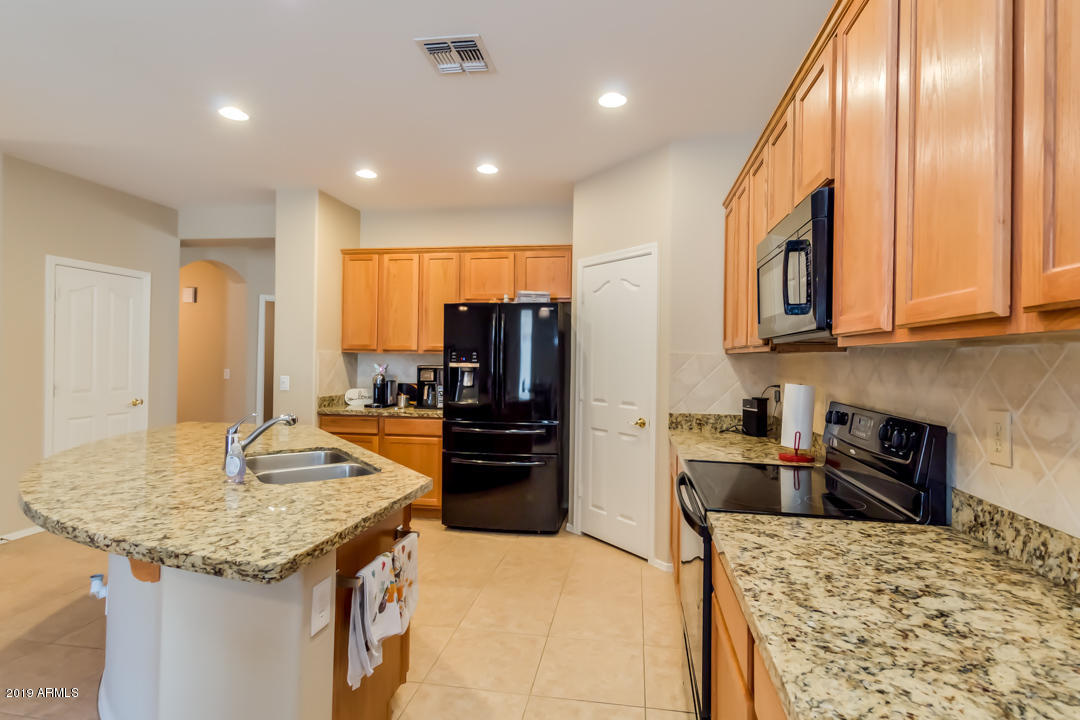 16528 West Sherman Street Goodyear, AZ 85338 - Photo 4 of 33 a kitchen with stainless steel appliances granite countertop microwave and refrigerator
