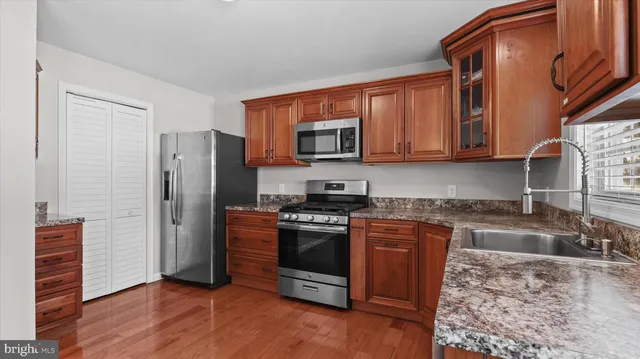 a kitchen with stainless steel appliances granite countertop a refrigerator stove and sink