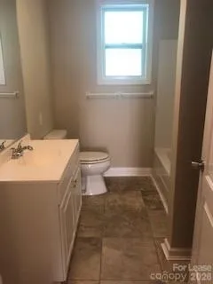 a bathroom with a sink a toilet and a window