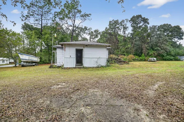 a view of a house with backyard and tree