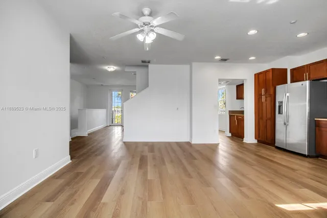 a view of a livingroom with a ceiling fan wooden floor and window