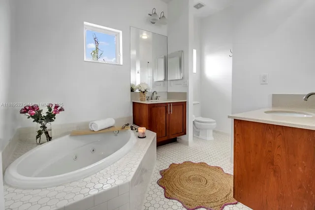 a bathroom with a tub sink and mirror