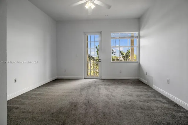 an empty room with windows and cabinet