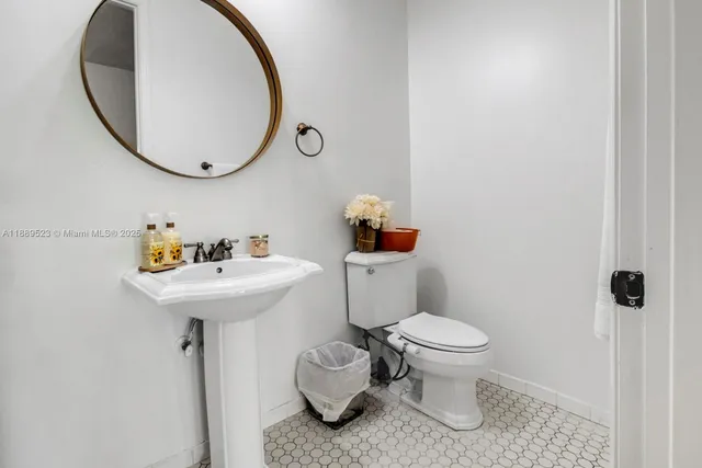 a bathroom with a sink toilet and a mirror