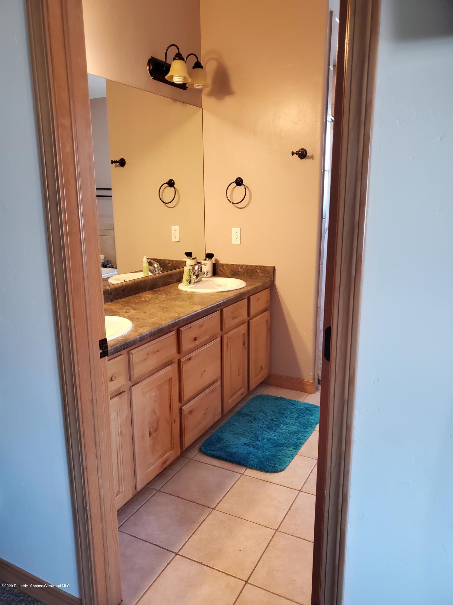 1880 Anvil Court Rifle, CO 81650 - Photo 13 of 16 a bathroom with a sink a mirror and shower