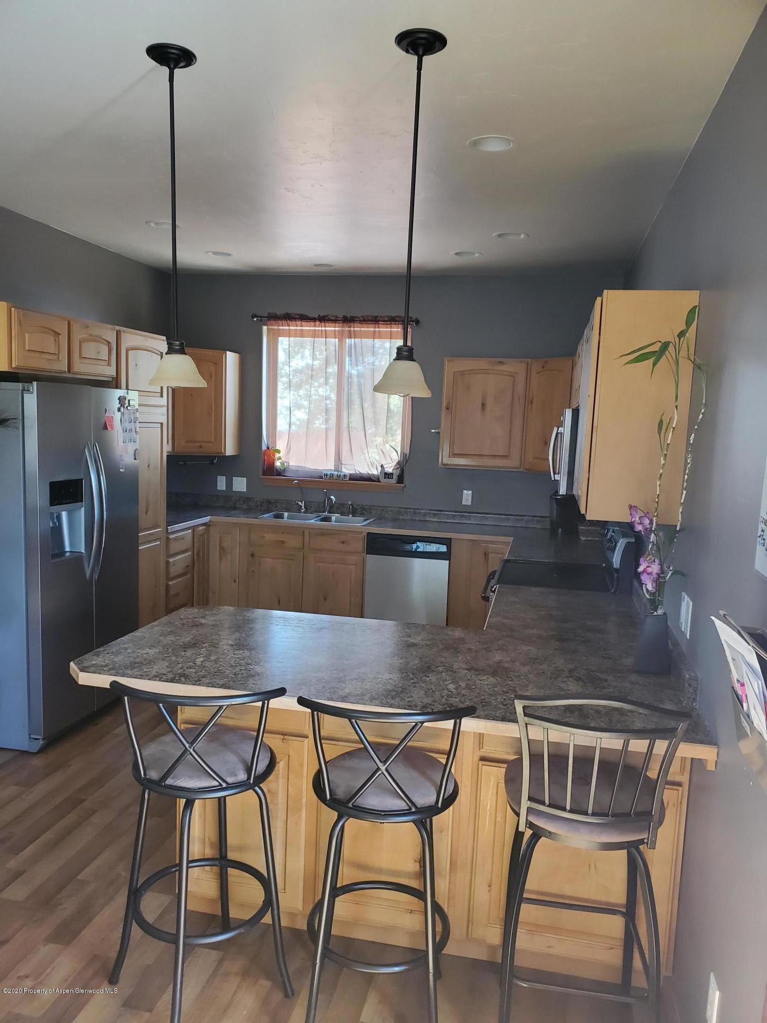 1880 Anvil Court Rifle, CO 81650 - Photo 4 of 16 a kitchen with a table chairs refrigerator and microwave