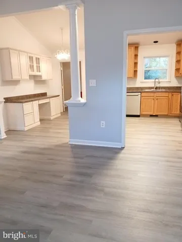 a view of a living room with kitchen island hardwood floor and a fireplace