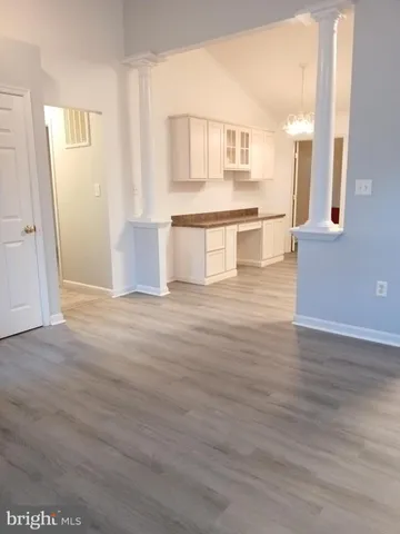 a view of a kitchen with wooden floor and a kitchen
