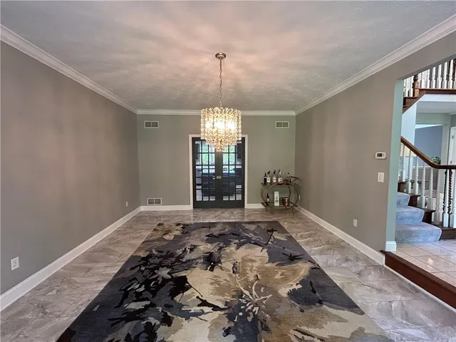 a view of a livingroom with wooden floor and a chandelier