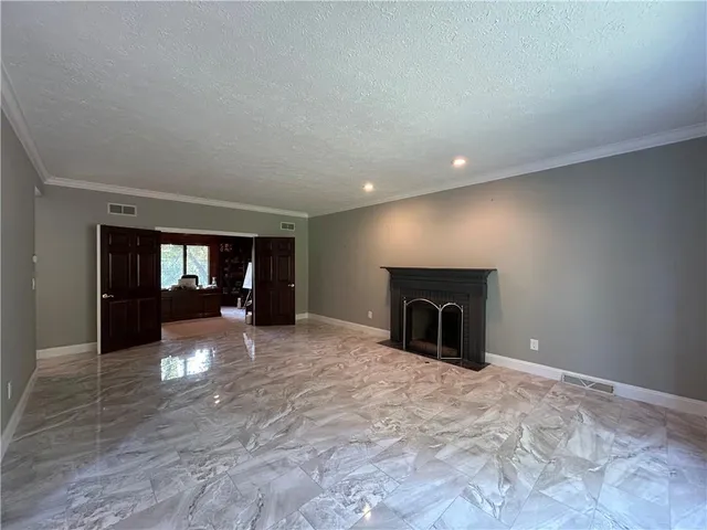 a view of a livingroom with an empty space and a fireplace