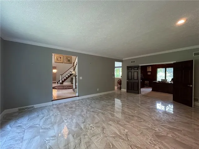 a view of empty room with window and wooden floor