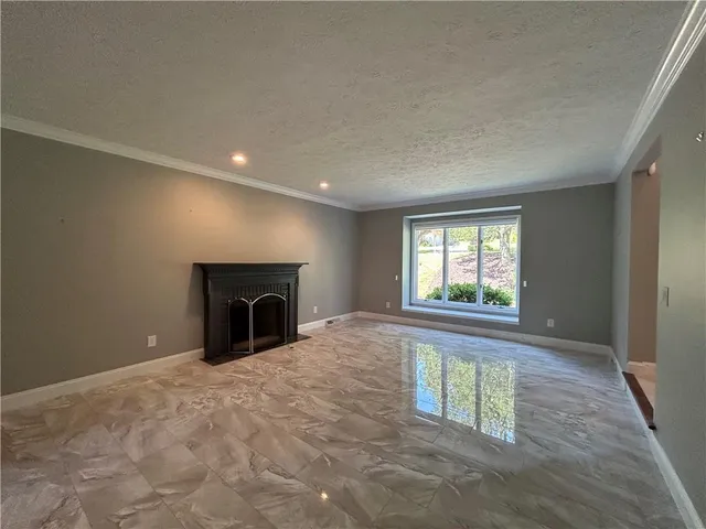 an empty room with fireplace and windows