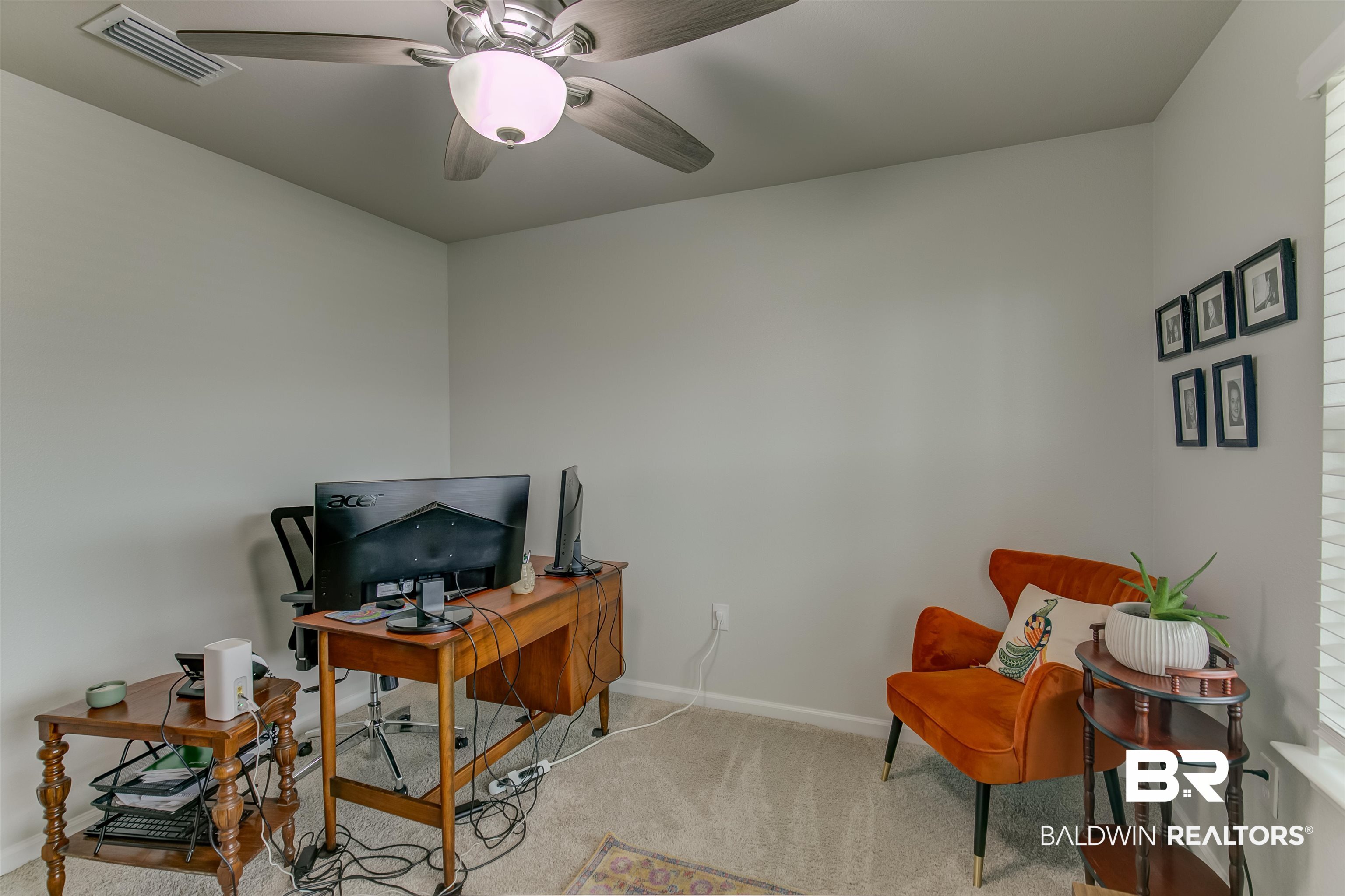 8033 Irwin Loop Daphne, AL 36526 - Photo 29 of 38 Neutral wall paint with carpet flooring, featuring a ceiling fan with integrated lighting and a window with blinds
