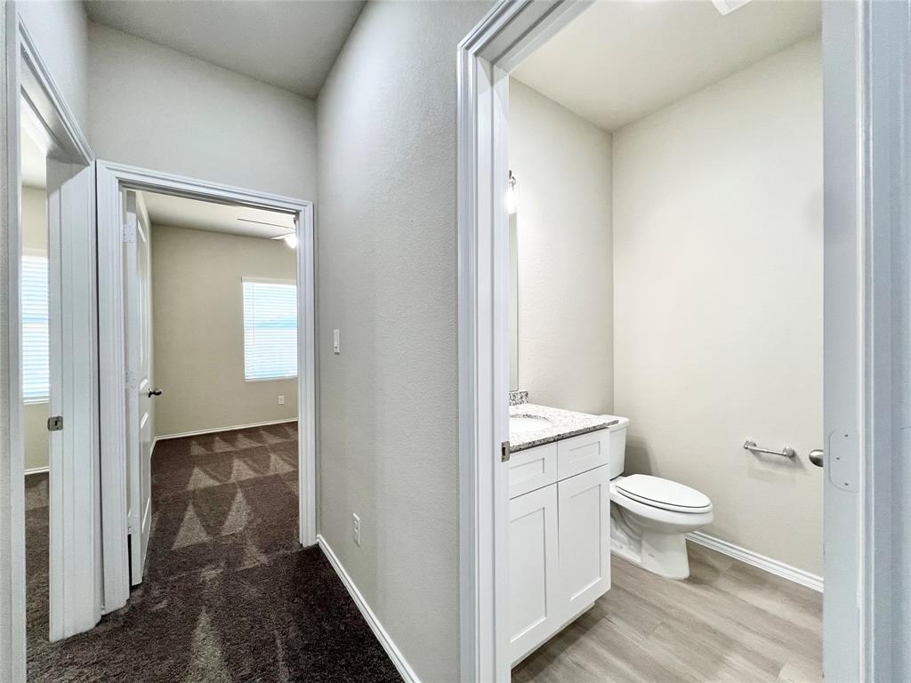 3501 East Renfro Street, Unit 603 Burleson, TX 76028 - Photo 20 of 35 a bathroom with a granite countertop toilet and a sink