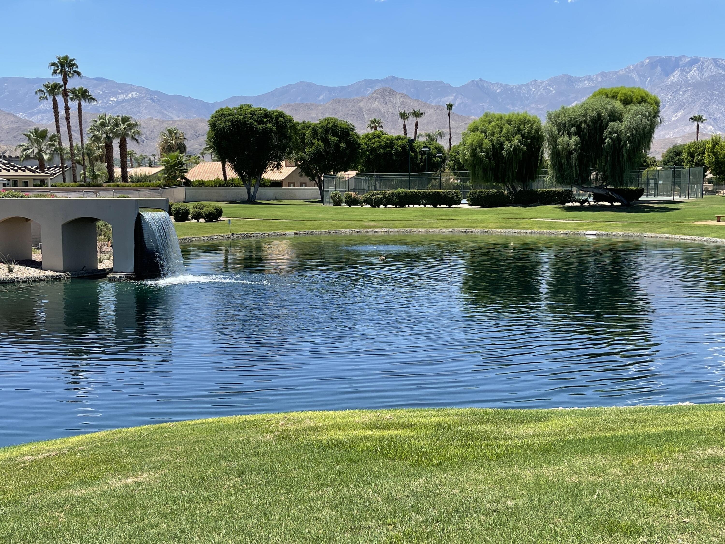 69573 Corta Celeste Cathedral City, CA 92234 - Photo 15 of 23 a view of a lake with a yard and large trees