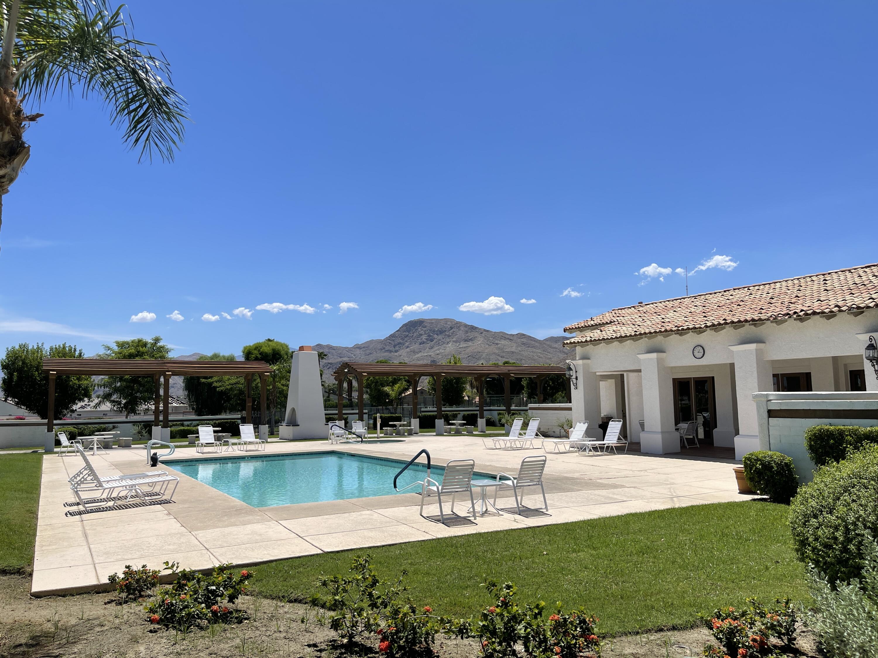 69573 Corta Celeste Cathedral City, CA 92234 - Photo 16 of 23 a view of a swimming pool with a table and chairs under an umbrella