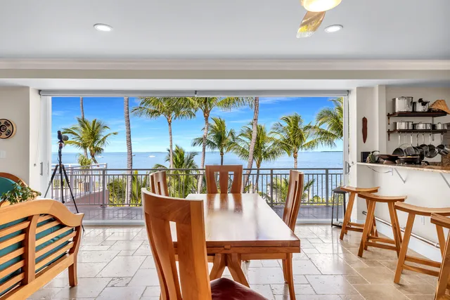 a dining area with furniture and a floor to ceiling window