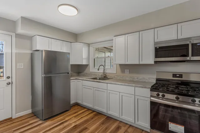 a kitchen with granite countertop a stove top oven sink and cabinets