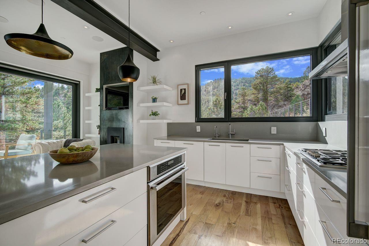 228 Lion Point Boulder, CO 80302 - Photo 18 of 50 a kitchen with stainless steel appliances white cabinets a stove a sink and a large window