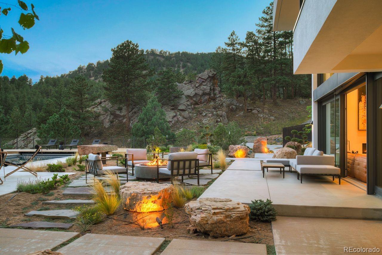 228 Lion Point Boulder, CO 80302 - Photo 48 of 50 a view of a patio with couches table and chairs under an umbrella