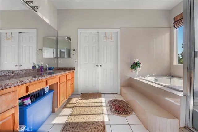 a large bathroom with a granite countertop tub a sink and a large mirror