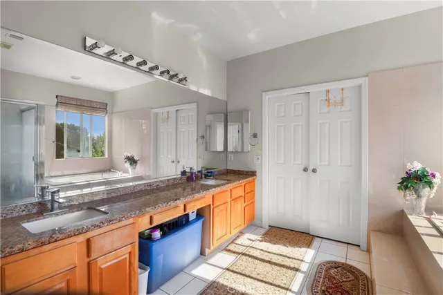 a spacious bathroom with a granite countertop sink and a mirror