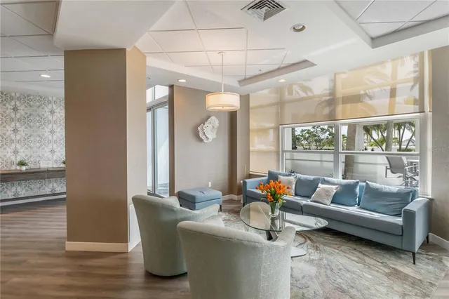 a kitchen with stainless steel appliances granite countertop a refrigerator a sink dishwasher a stove and white countertops with wooden floor