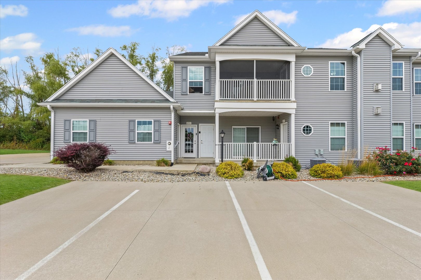 3044 East Stillwater Landing, Unit 201 Urbana, IL 61802 - Photo 1 of 28 a front view of a house with a yard and garage