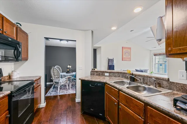 a kitchen with a sink stove and wooden floor