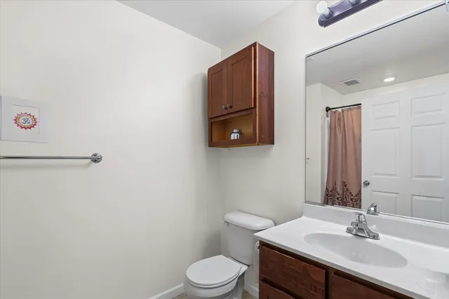 a bathroom with a sink vanity mirror and toilet