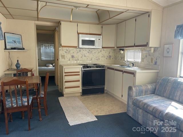 5400 Little River Neck Road, Unit 269 North Myrtle Beach, SC 29582 - Photo 7 of 22 a kitchen with stainless steel appliances granite countertop a stove top oven a sink dishwasher and white cabinets