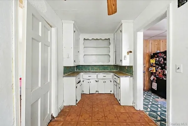 a hallway with white cabinets and wooden floor