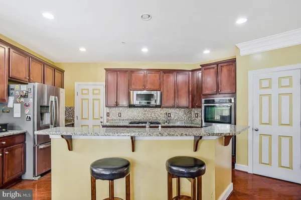 a kitchen with stainless steel appliances granite countertop refrigerator stove microwave and sink