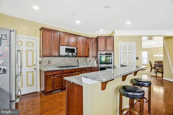 a kitchen with wooden cabinets stainless steel appliances a sink and a window